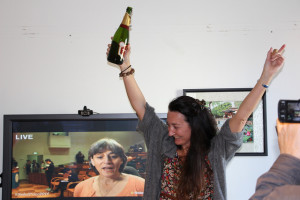 May-Britt Moser, Nobel laureate, celebrates after the prize is announced. Juleen xx, chairman of the Nobel committee , is on the TV behind her. Photo: Nancy Bazilchuk, NTNU