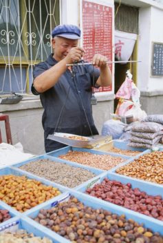 Man selling nuts and dried fruit in Dunhuang, China