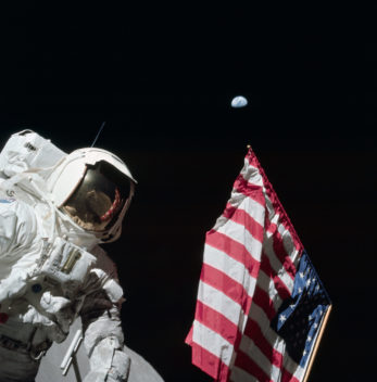 Astronaut Harrison "Jack" Schmitt with the American flag during Apollo 17, the last mission to the Moon. The Earth is the tiny blue marble in the background, 400 000 km away. Photo: NASA