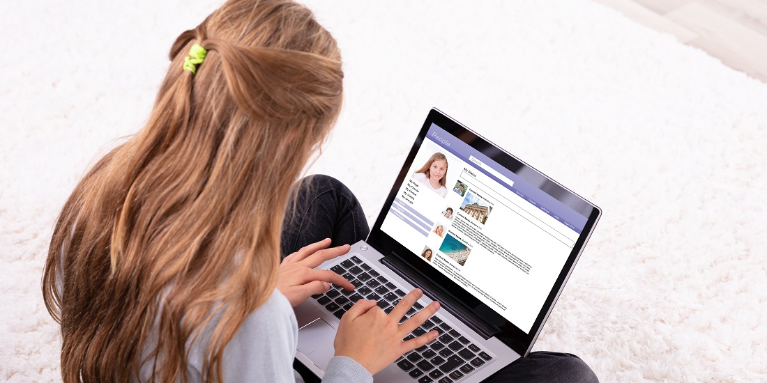 A young girl is using a social media website