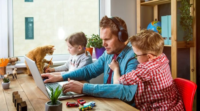 A man working from home, surrounded by kids and animals.