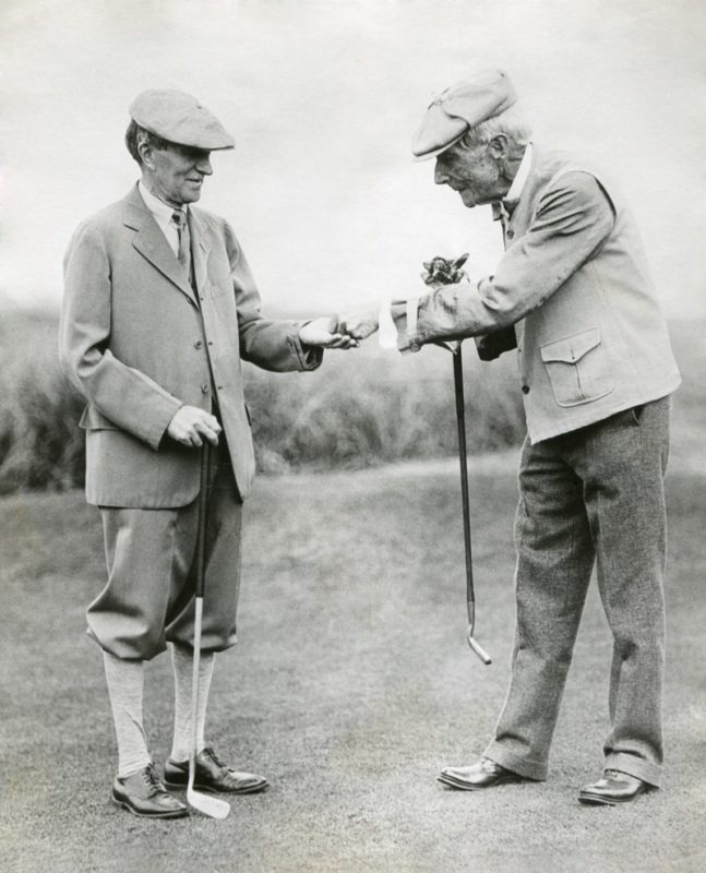 John D. Rockefeller, right, gives businessman Harvey Firestone 10 cents as a reward for a good golf shot.