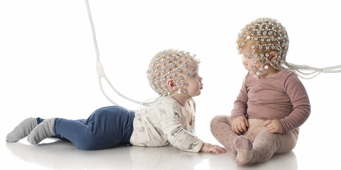 Two toddlers with some kind of electrical equipment on their heads
