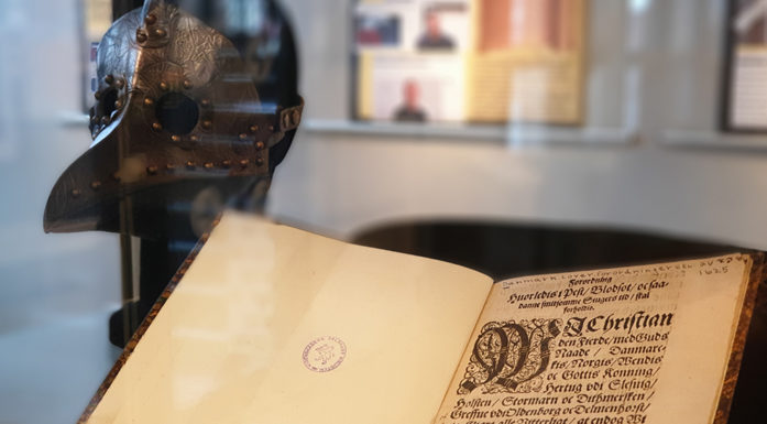An old doctor's mask and a book in a museum