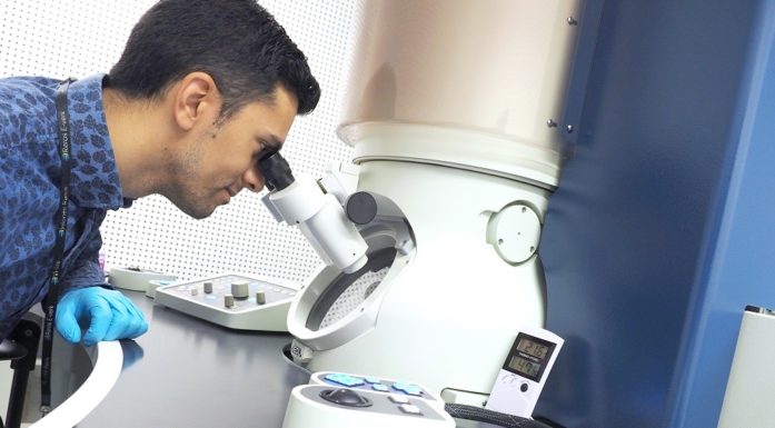 Adrian Lervik looking through the microscope