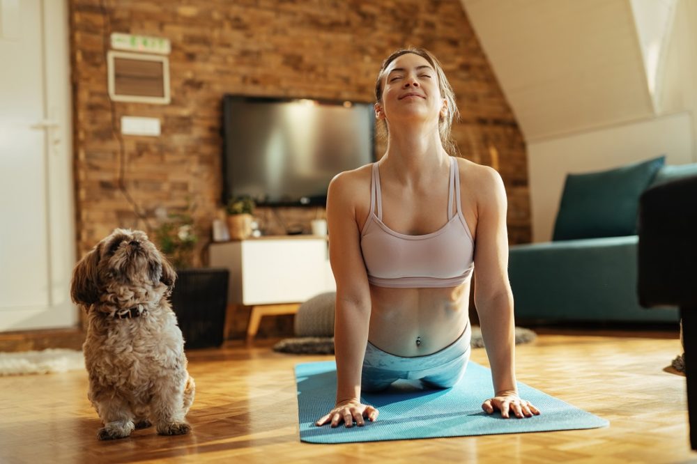 woman doing yoga with a dog