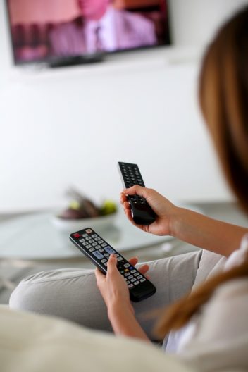 A woman holding tv-remotes