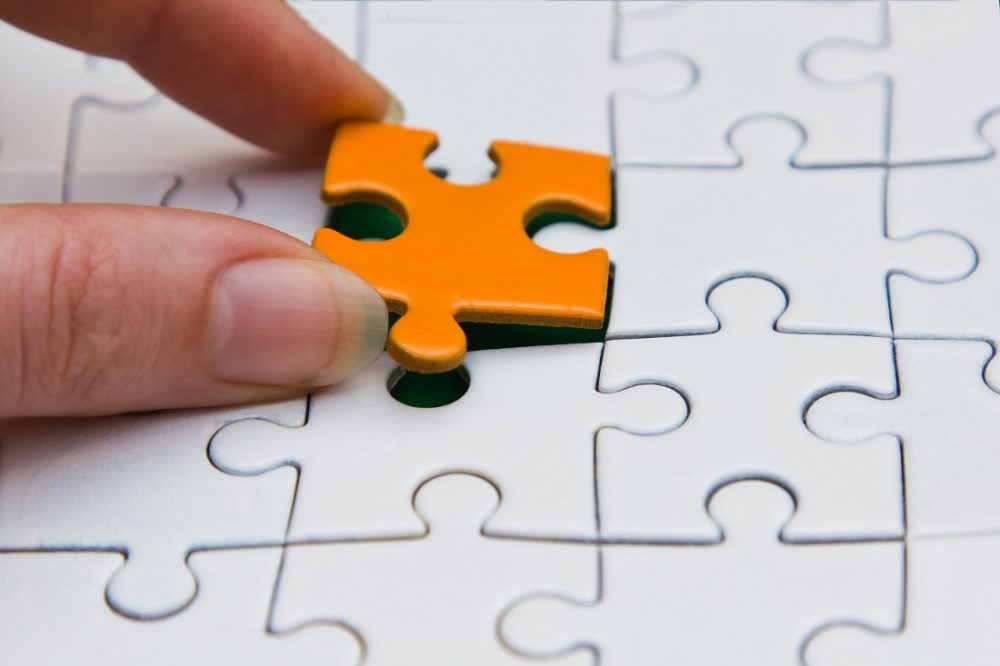 Puzzle piece being put in a puzzle