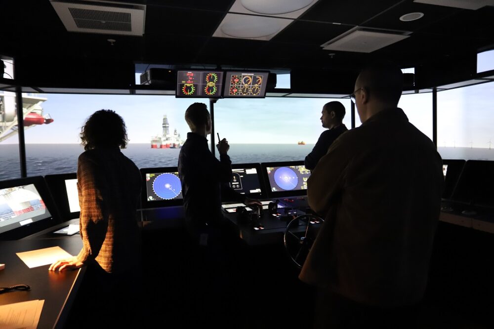 Three people in a ship simulator.