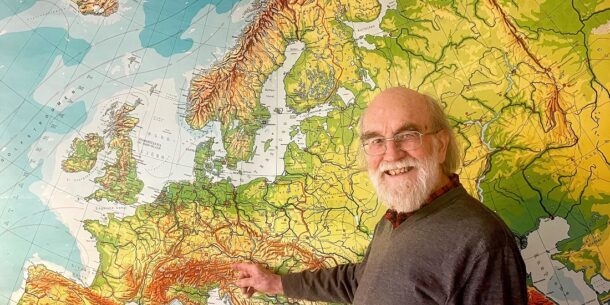 Picture of Professor emeritus Michael Jones in front of an old map of Europe