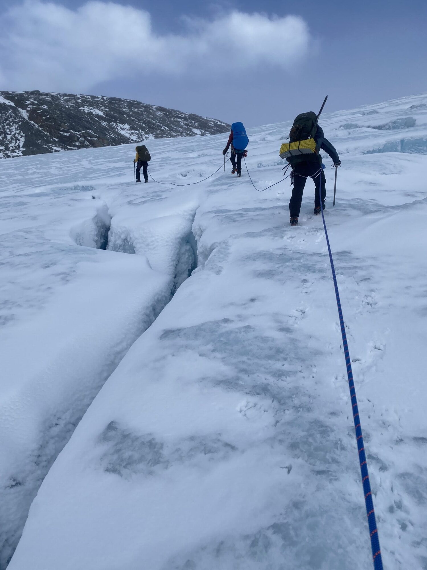A group of researchers wants to help communities living close to melting glaciers. Photos shows the group walking on a glacier.