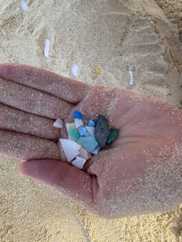 Small pieces of plastic in the palm of a hand. Photo.