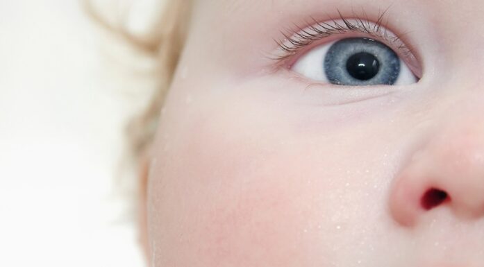 Closeup of an infant's face and one blue eye. Photo illustration.