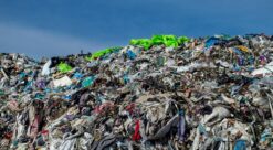 A vast heap of discarded clothing at a landfill. Photo.