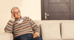 Older Man on sofa looking sad. Photo.