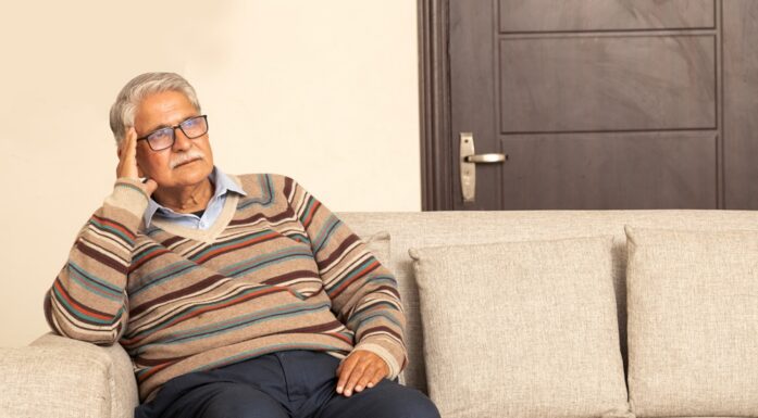 Older Man on sofa looking sad. Photo.