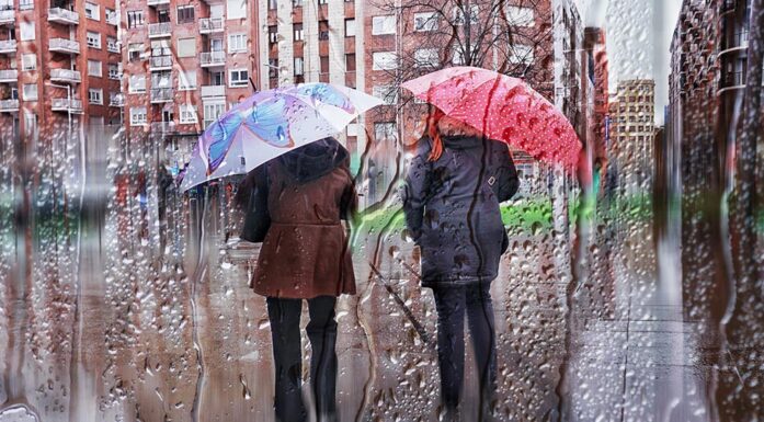 Two people under an umbrella in the rain.