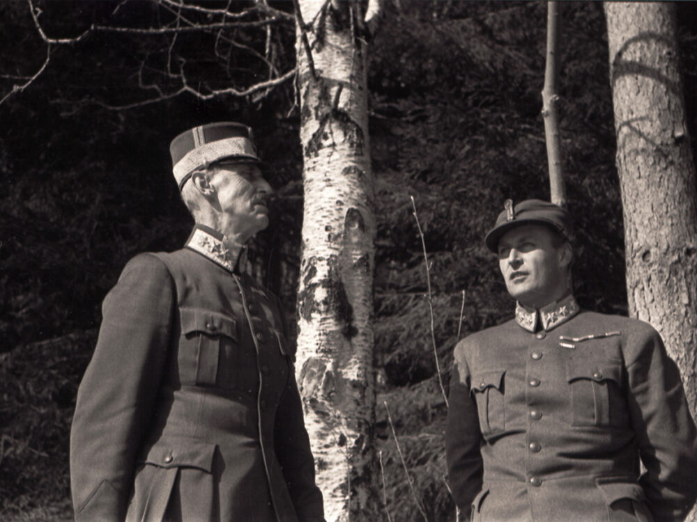 King Haakon VII and Crown Prince Olav pictured in woodland setting, during wartime 