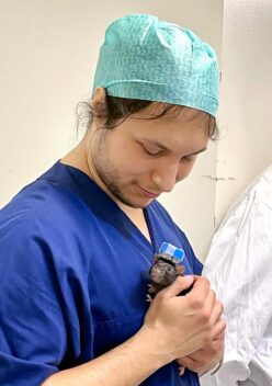 Michael Schellenberger is holding a rat in his hands against his chest. Photo.