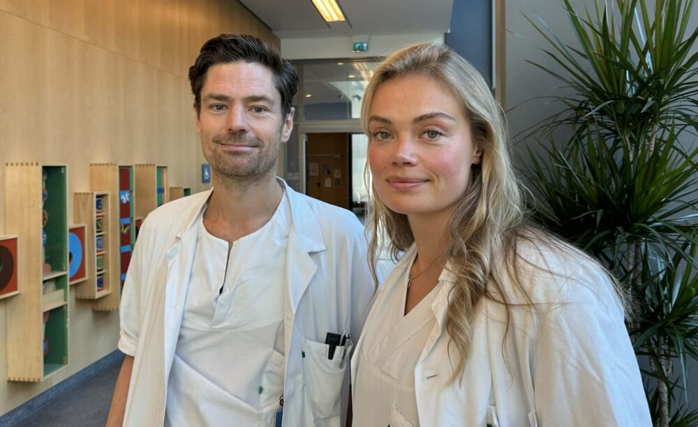 Two researchers in white doctor clothes in hallway