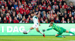 striker and goalkeeper battle for ball in football match