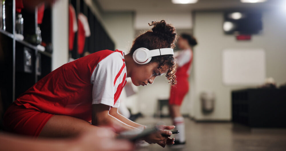 Girl, soccer player and headphones in locker room 