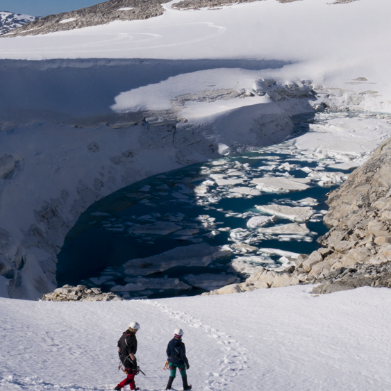 A group of researchers wants to help communities living close to melting glaciers. Photos shows the group walking on a glacier. A group of researchers wants to help communities living close to melting glaciers. Photos shows two persons walking nearby a demmed lake.